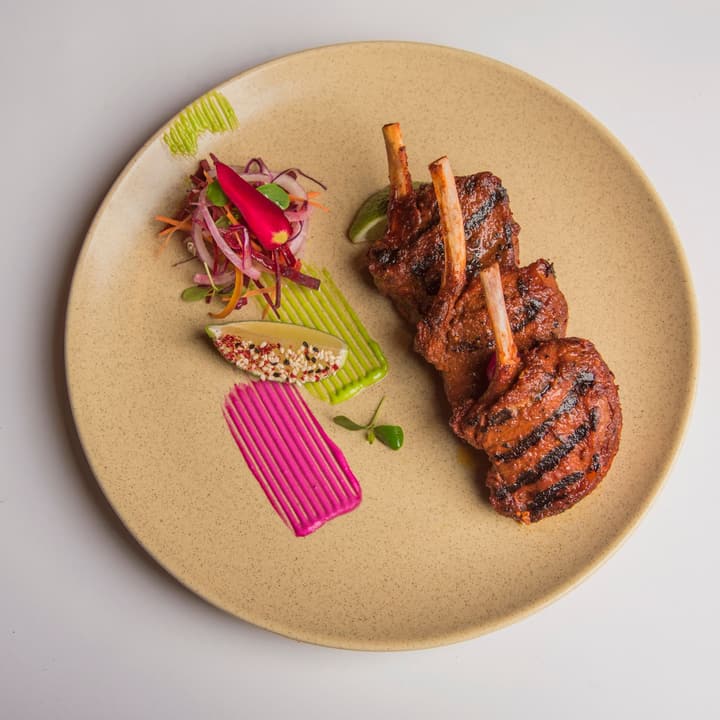 Costolette di agnello alla griglia con puree colorate e insalatina di cipolla marinata