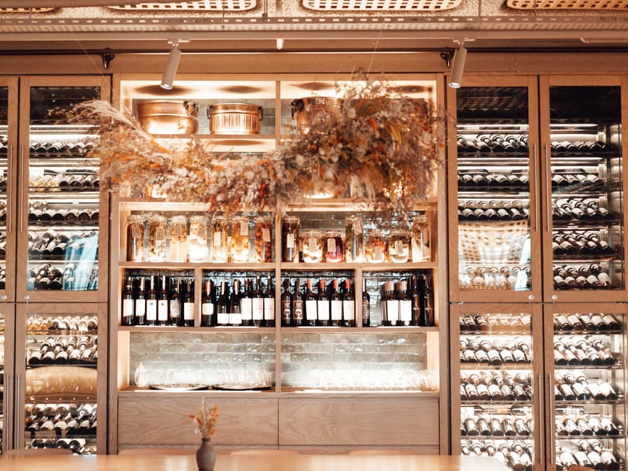 La parete della cantina con le bottiglie nelle rastrelliere illuminate